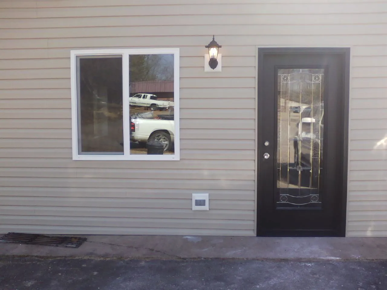 New siding, window and entry door on the side of an addition in Warrendale