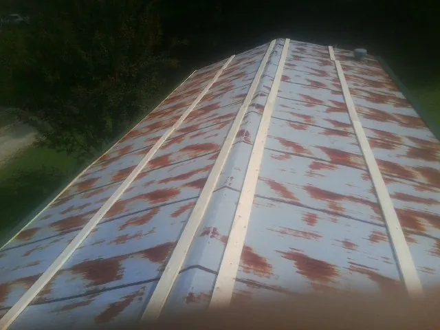 Rusted metal roof panels with new wood purlins before replacement — Storm Damage Roof Repair in Warrendale by Roofing Brothers