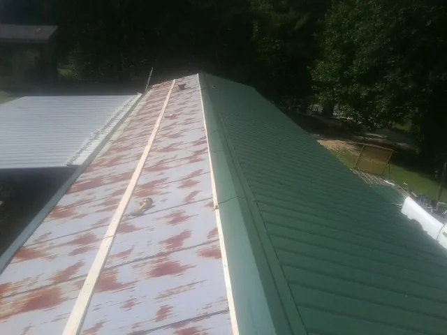 Old rusted panels beside newly installed green metal roofing — Wind Damage Roof Repair by Roofing Brothers in Warrendale