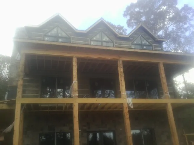 Dormers and porch framing on a large log home under construction — Roof Coating work by our crew in Warrendale