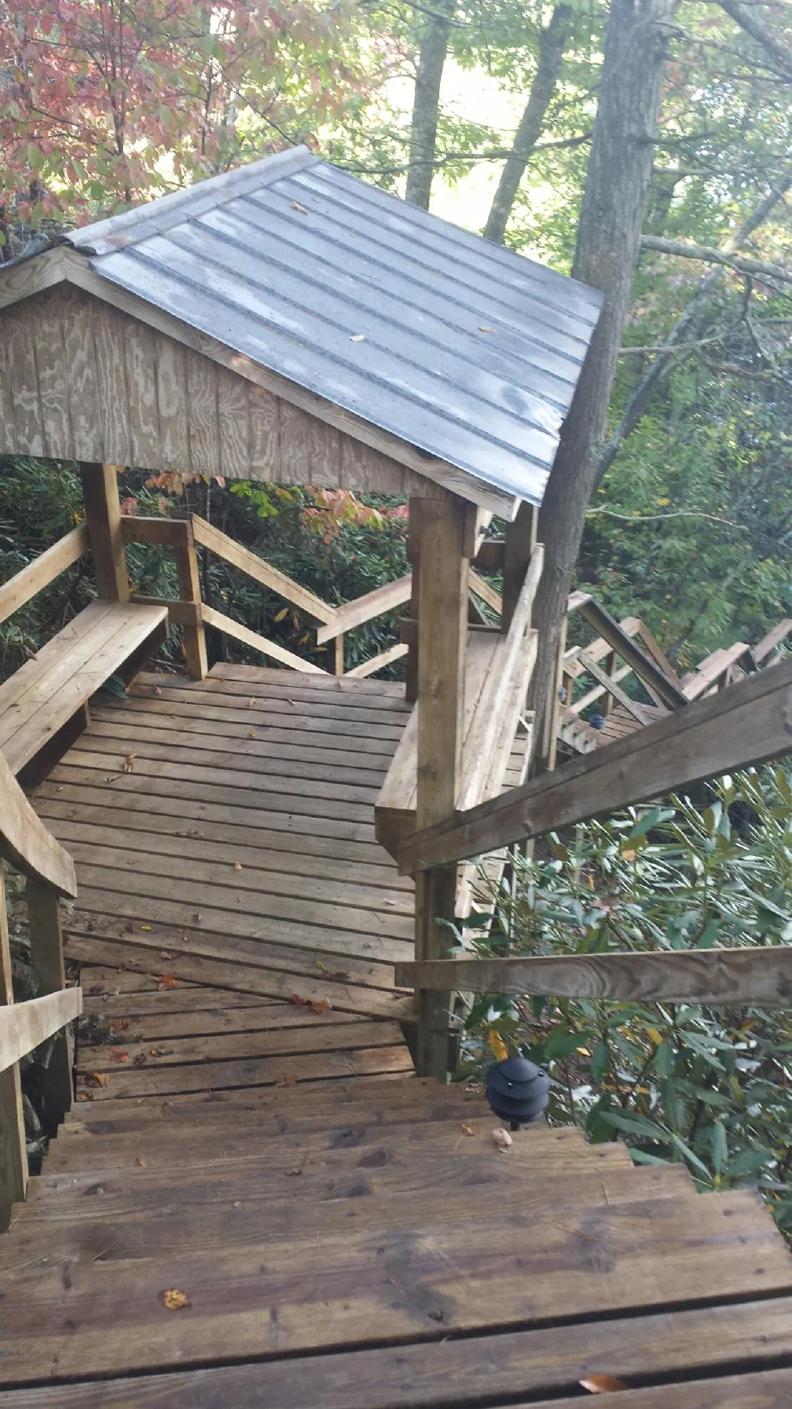 Metal roofed shelter over wooden steps on a wooded walkway — Skylight Repair & Installation work by our crew in Warrendale
