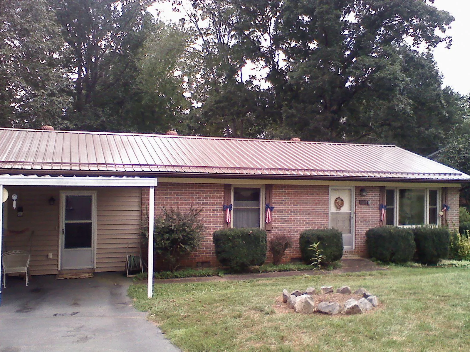 Bronze metal roof and carport on a brick ranch home — Roof Repair work by our crew in Warrendale